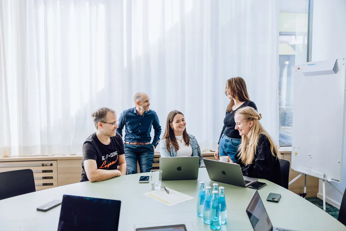 People in meeting room discussing projects